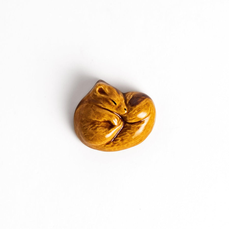 Adorable brown ceramic chopstick rest shaped like a sleeping squirrel, adding a touch of woodland charm to your table setting.