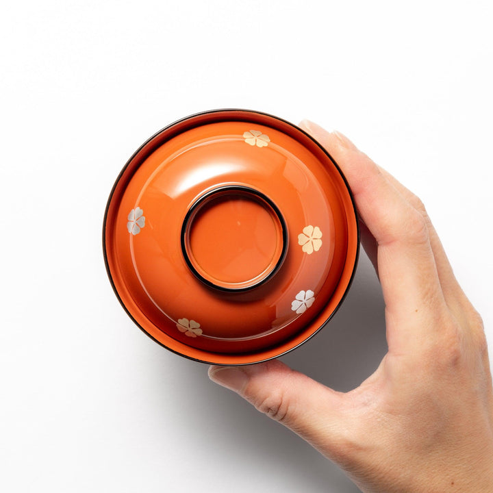 A lidded soup bowl with a warm brown color, adorned with small golden floral patterns.