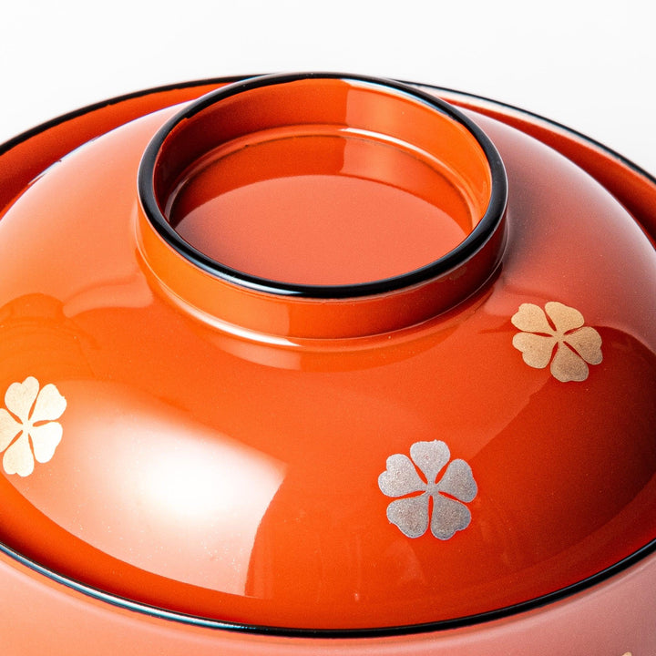 A lidded soup bowl with a warm brown color, adorned with small golden floral patterns.