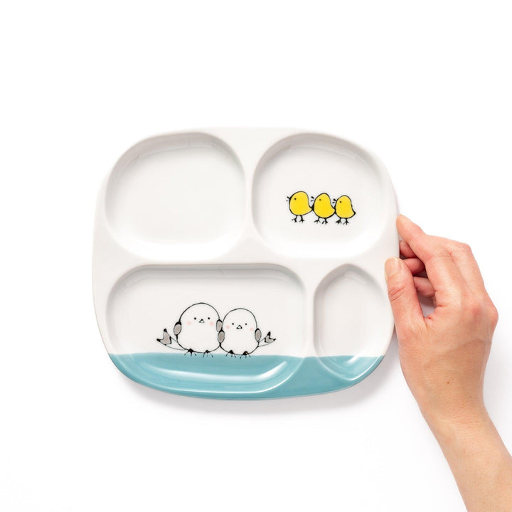 Adorable kids' plate featuring two snowbirds at the bottom and three yellow chicks at the top, with a light blue accent, perfect for brightening up mealtime.