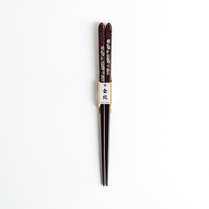 Two pairs of chopsticks, one in deep purple and the other in red, each decorated with subtle gold accents and a speckled finish.