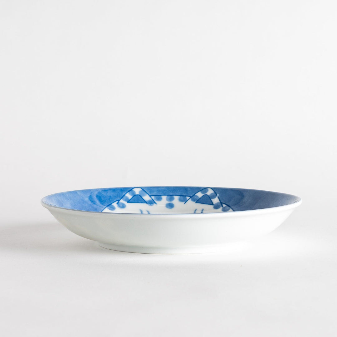 A salad plate featuring a chubby blue-spotted white cat with a contented expression.