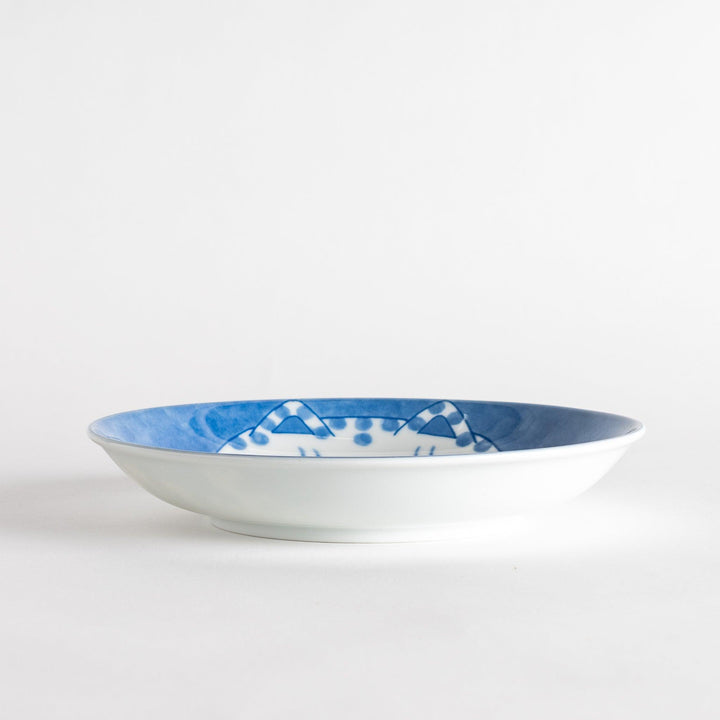 A salad plate featuring a chubby blue-spotted white cat with a contented expression.