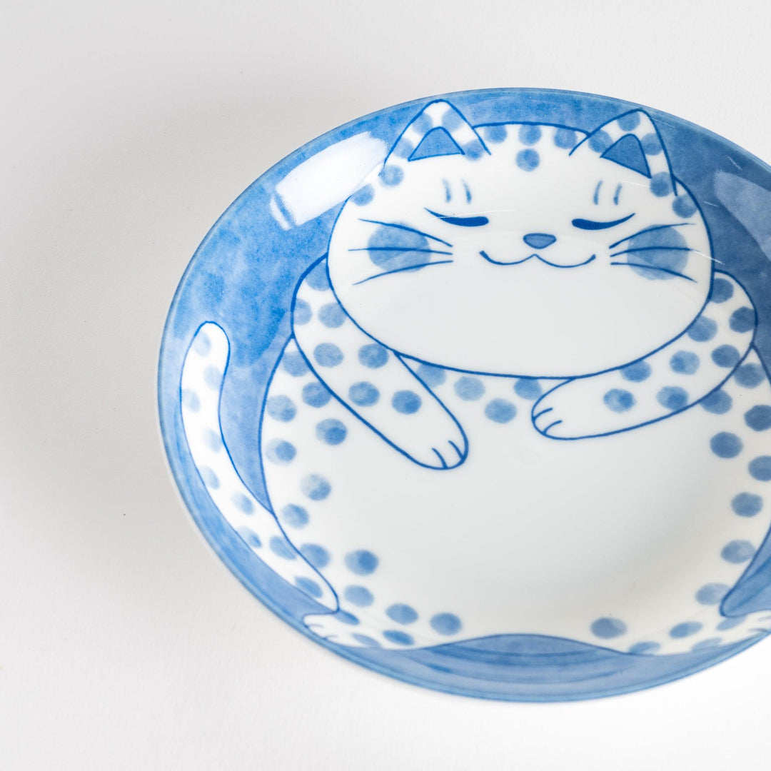 A salad plate featuring a chubby blue-spotted white cat with a contented expression.
