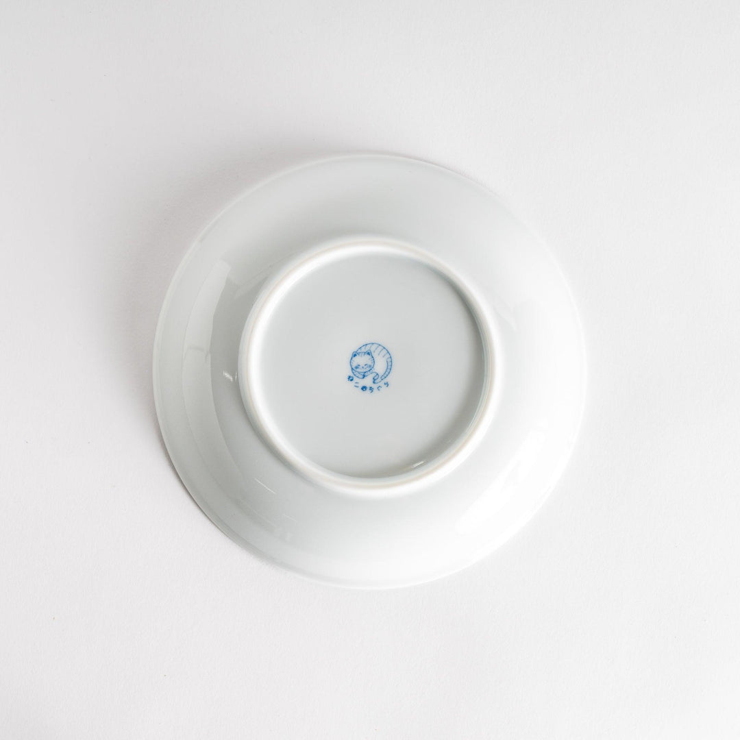 A salad plate featuring a chubby blue-spotted white cat with a contented expression.