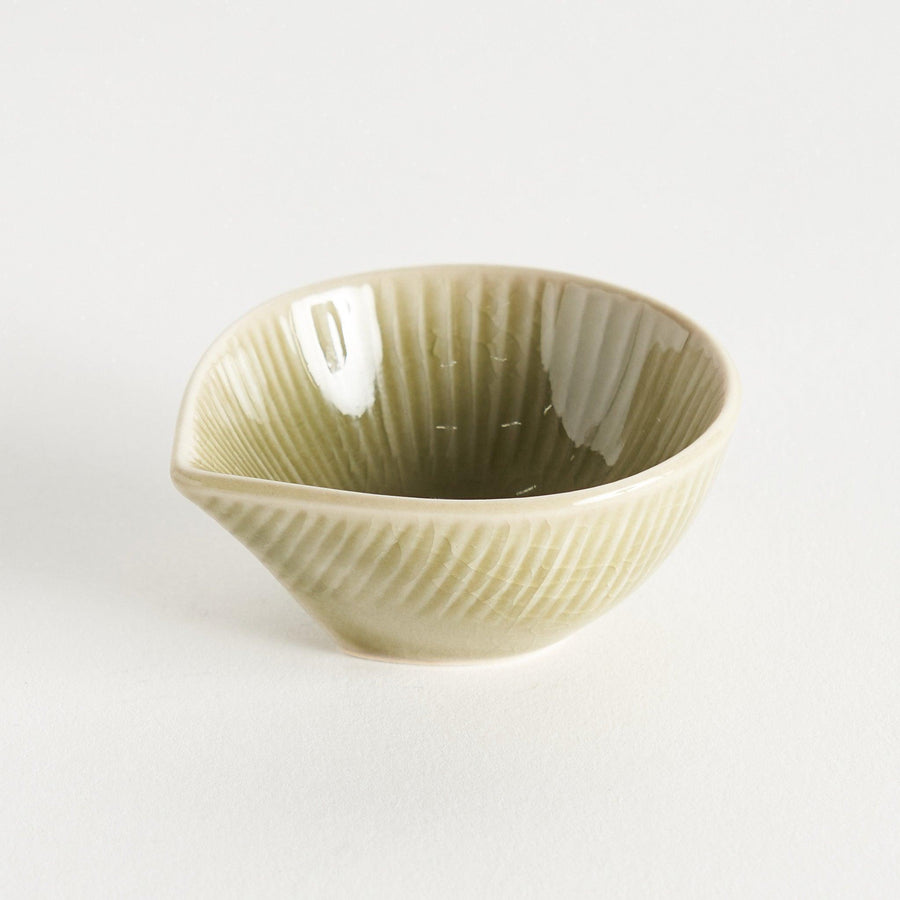 A small condiment bowl with a light green textured surface.