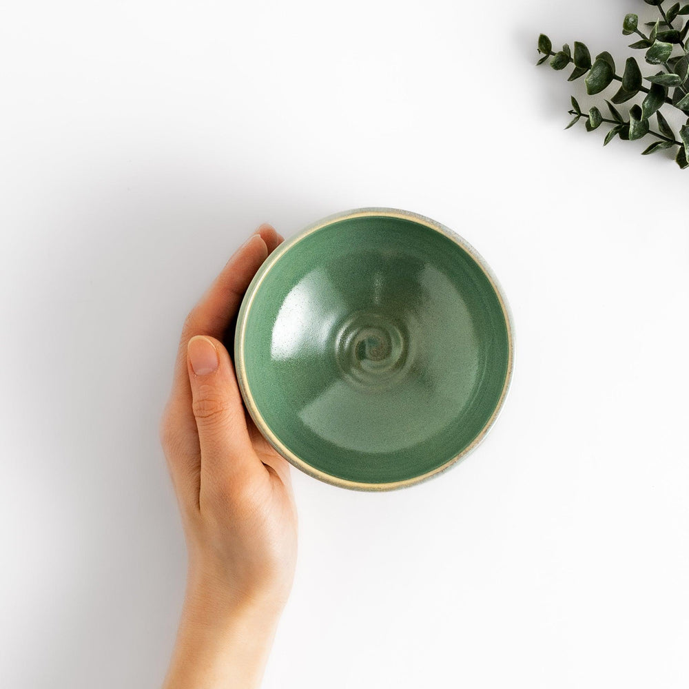 Unique ceramic Matcha bowl with a beautiful green glaze and a rustic base, perfect for enjoying a traditional Japanese tea ceremony.