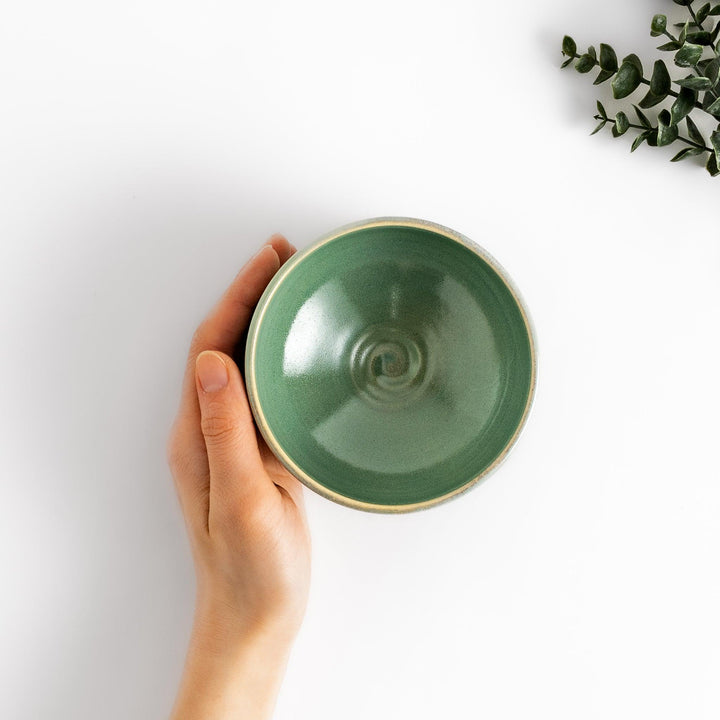 Unique ceramic Matcha bowl with a beautiful green glaze and a rustic base, perfect for enjoying a traditional Japanese tea ceremony.