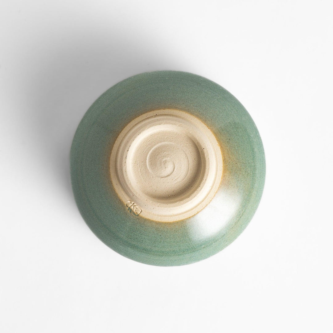 Unique ceramic Matcha bowl with a beautiful green glaze and a rustic base, perfect for enjoying a traditional Japanese tea ceremony.
