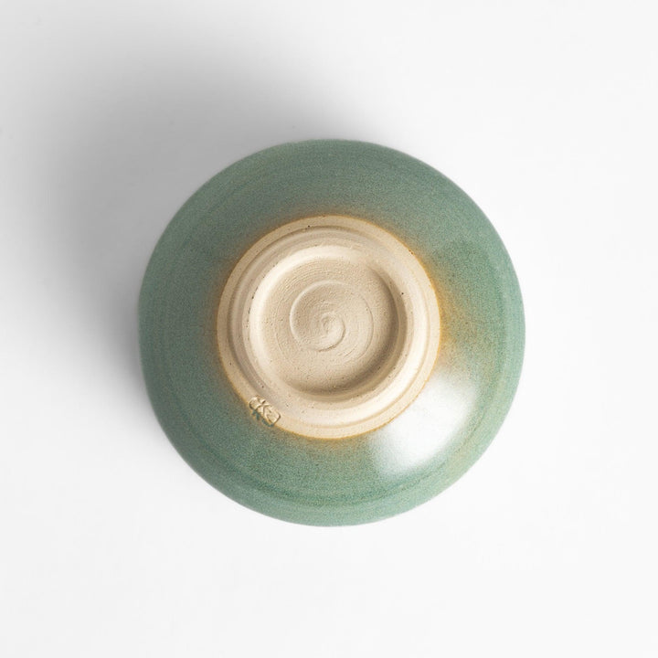 Unique ceramic Matcha bowl with a beautiful green glaze and a rustic base, perfect for enjoying a traditional Japanese tea ceremony.