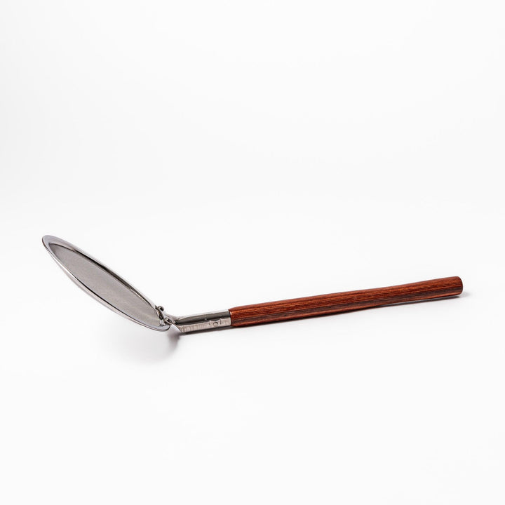 Stainless steel round-mesh skimmer with long wooden handle, perfect for straining soups and frying in home kitchens.