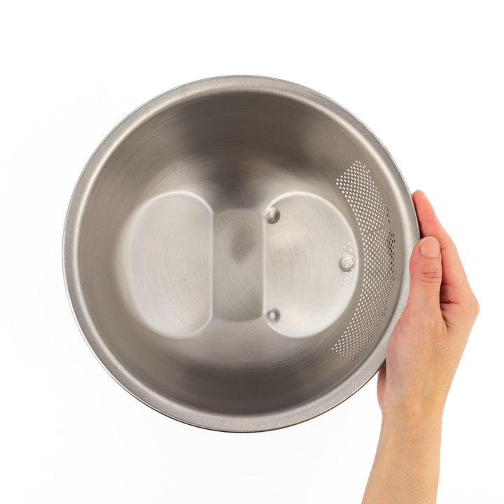Stainless steel rice washing bowl viewed from above, featuring dual drainage sections—perforated and slotted—for quick, efficient rinsing.