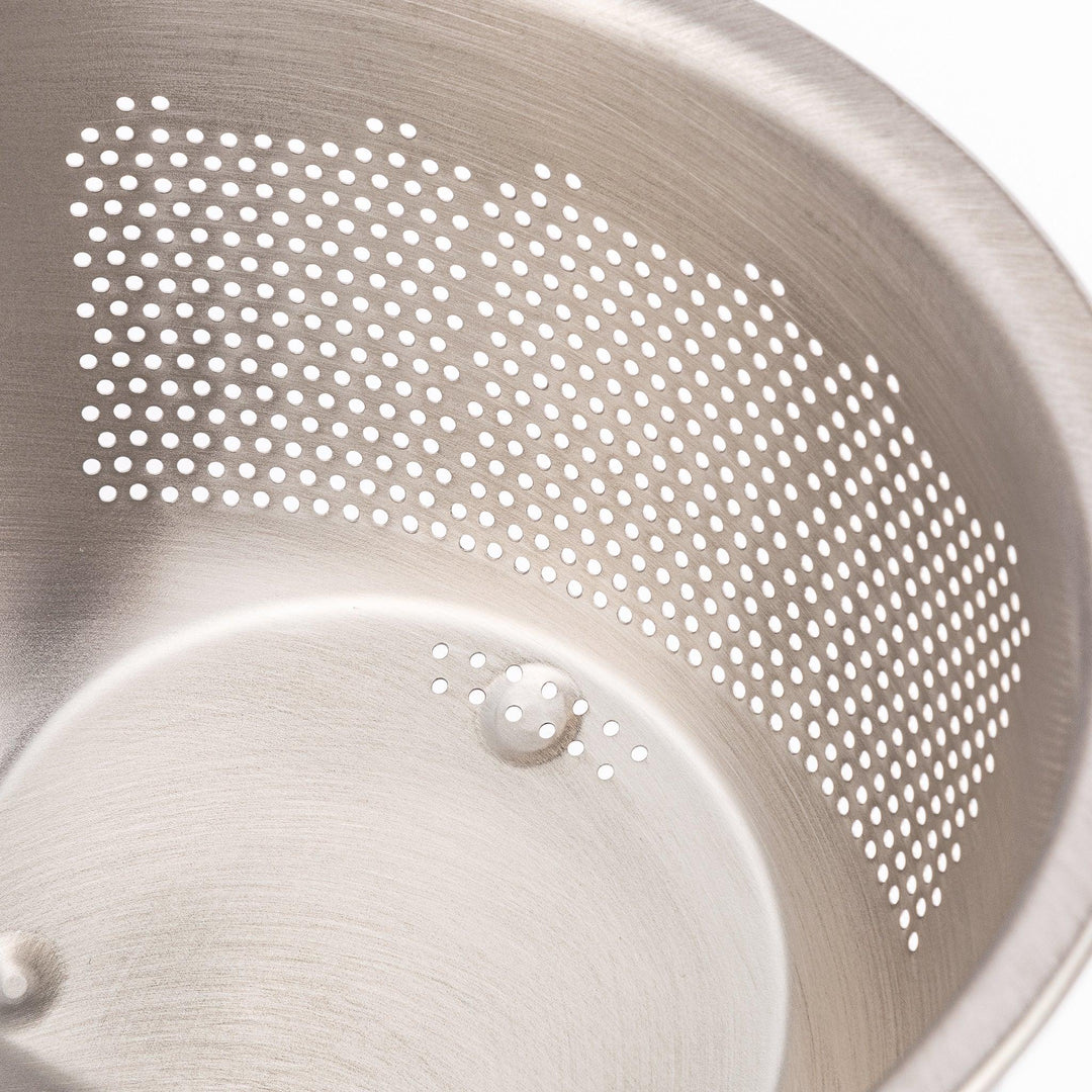 Stainless steel rice washing bowl viewed from above, featuring dual drainage sections—perforated and slotted—for quick, efficient rinsing.