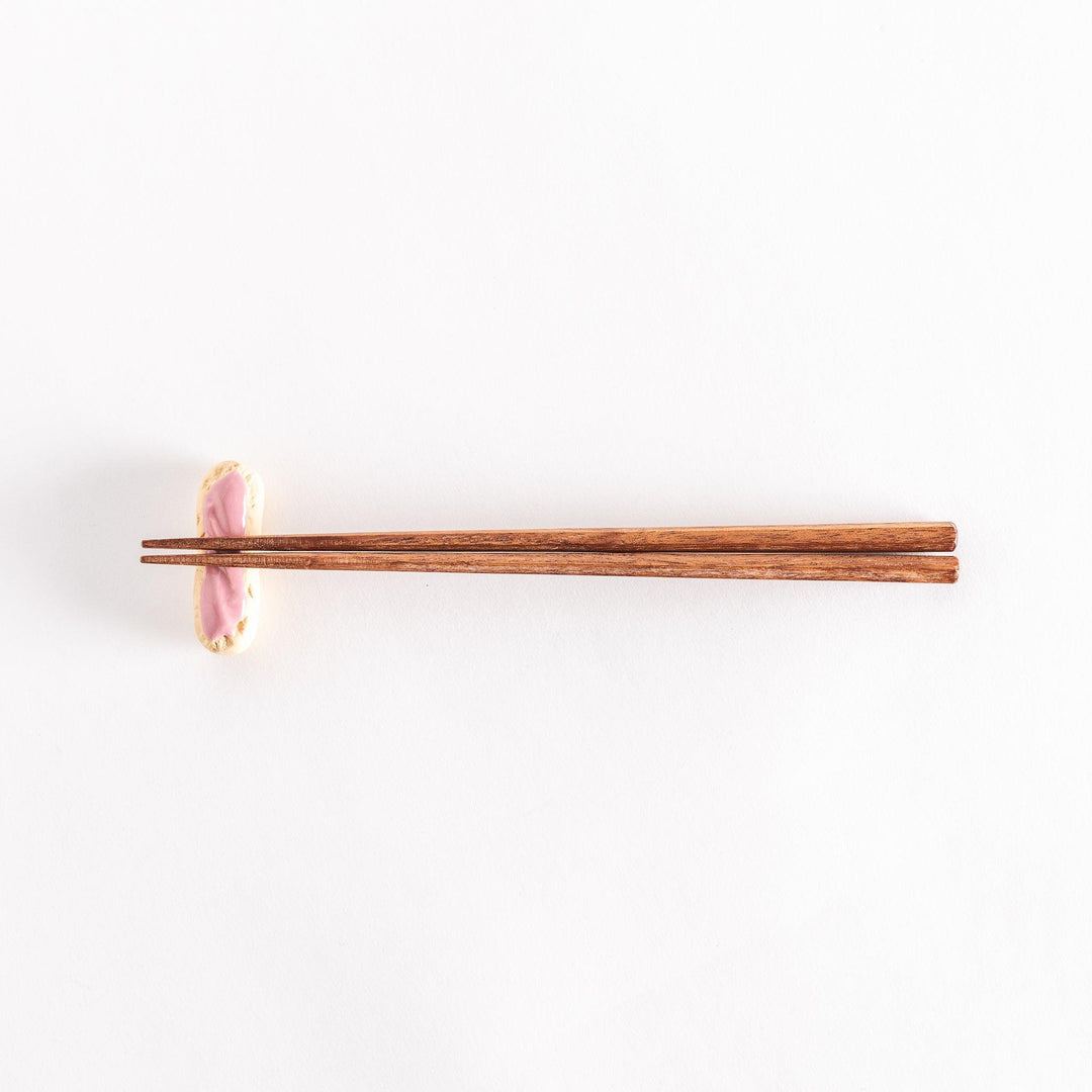 Full view of the strawberry éclair chopsticks rest with chopsticks placed across it.
