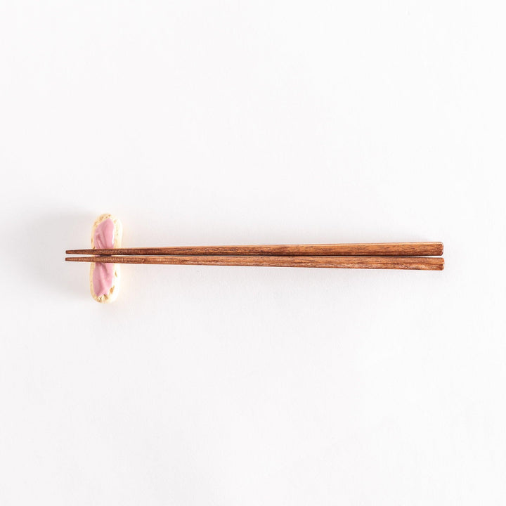 Full view of the strawberry éclair chopsticks rest with chopsticks placed across it.