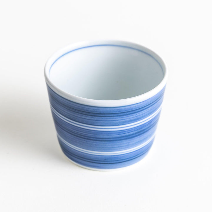 A small condiment bowl with horizontal blue or red stripes of varying shades, creating a minimalist yet elegant design.