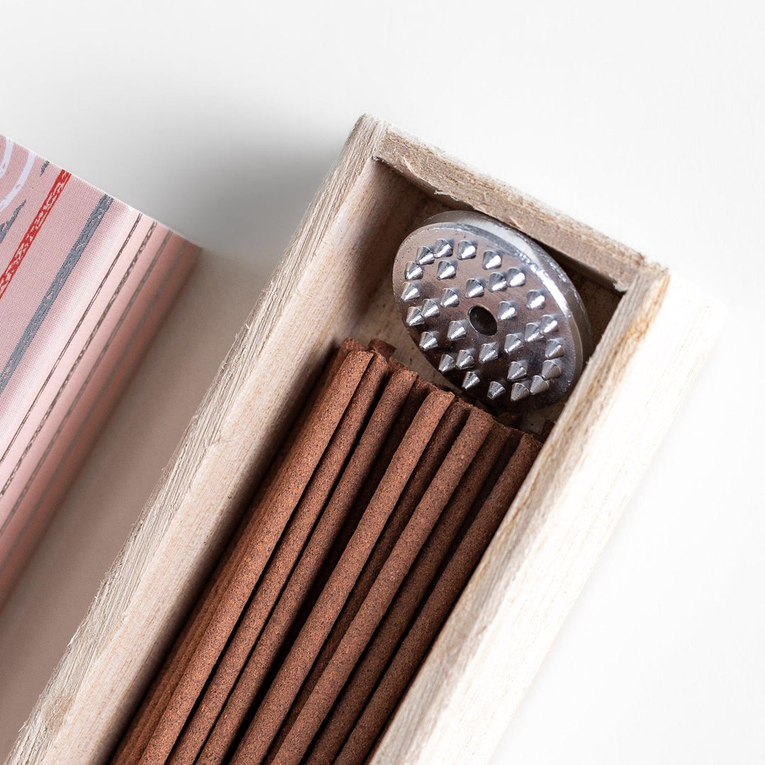 Sweet Peach Incense in a light wooden box with warm brown sticks, elegantly packaged in a soft pink design featuring white circular patterns, evoking a delicate and fruity peach aroma.