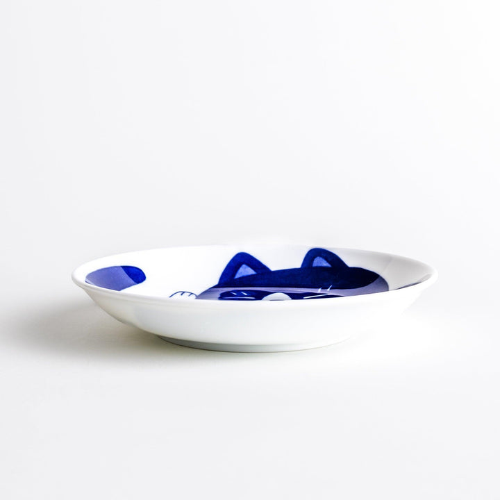 A salad plate featuring a playful black and white cat stretching contentedly.