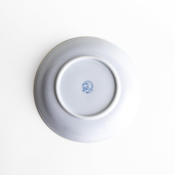 A salad plate featuring a playful black and white cat stretching contentedly.