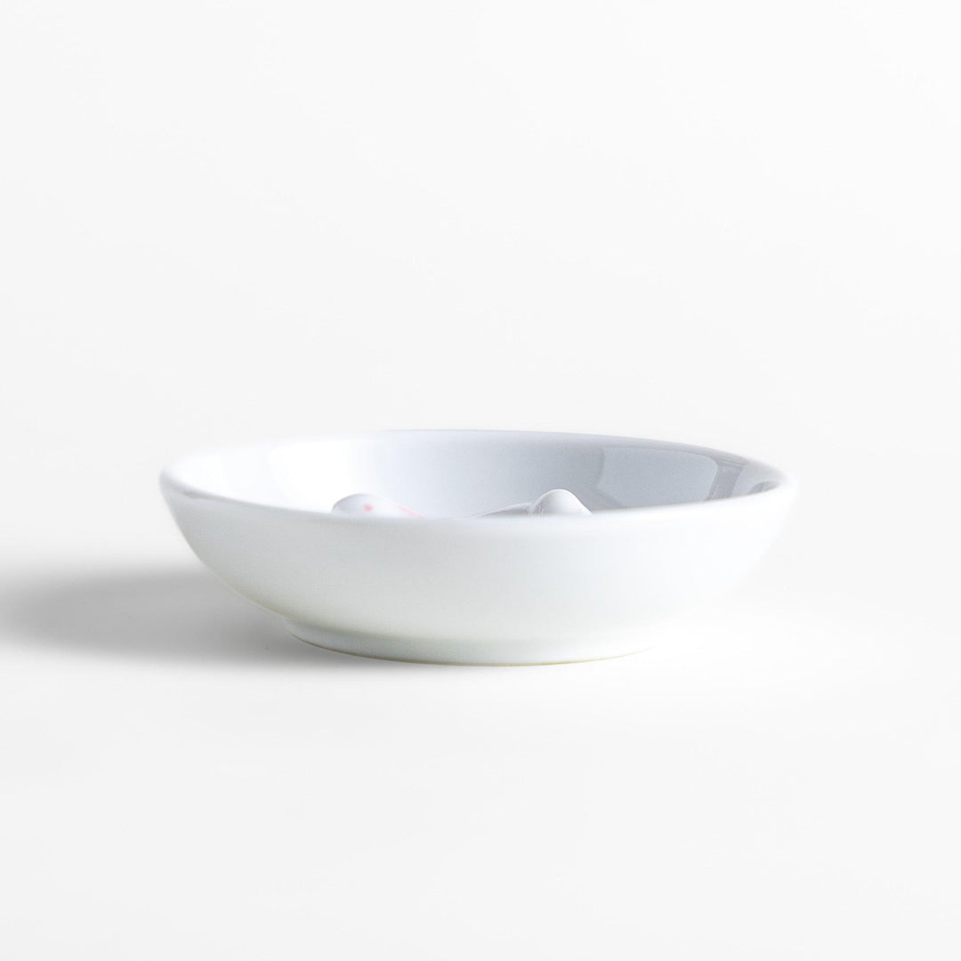 White ceramic incense holder set featuring a round dish and a rabbit-shaped holder with pink accents, designed to catch ash neatly while adding a charming touch.