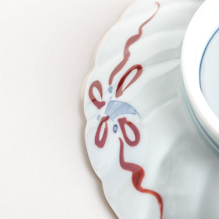 A deep porcelain bowl with an intricate Imari-style design, featuring a central landscape scene and alternating floral patterns in red, blue, and gold.