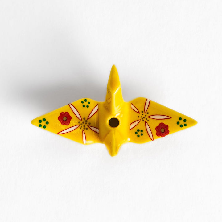 Colorful yellow origami crane incense holder with intricate floral patterns, perfect for adding charm and serenity to your space.