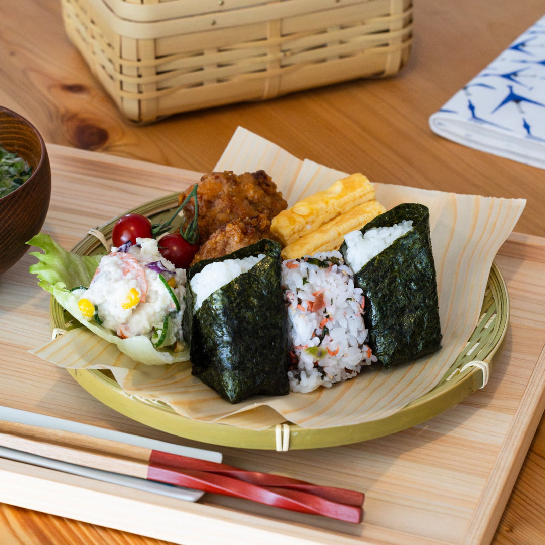 Medium Japanese bamboo zaru strainer basket served with onigiri and side dishes on a wooden tray