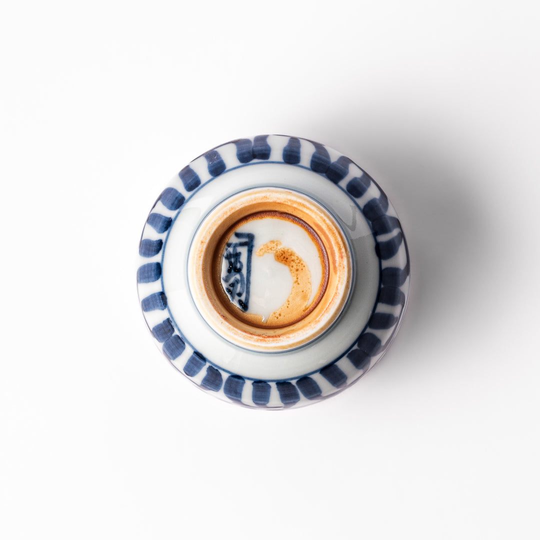 Porcelain sake cup featuring intricate blue landscape and arabesque patterns with a traditional hand-painted indigo design.