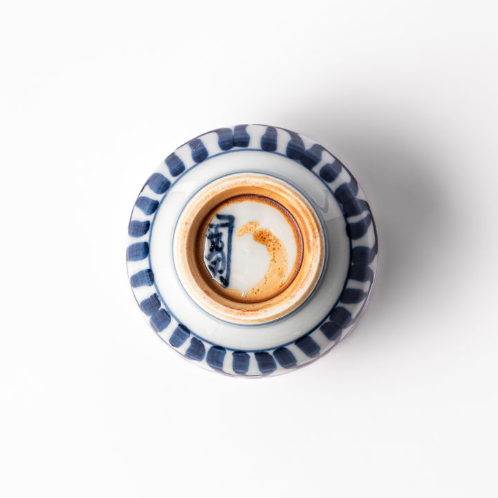 Porcelain sake cup featuring intricate blue landscape and arabesque patterns with a traditional hand-painted indigo design.