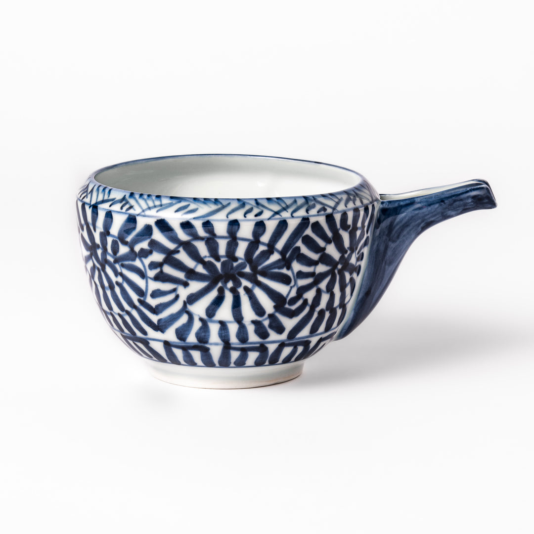Porcelain sake pourer with spout featuring hand-painted indigo landscape and arabesque patterns in a traditional Japanese style.