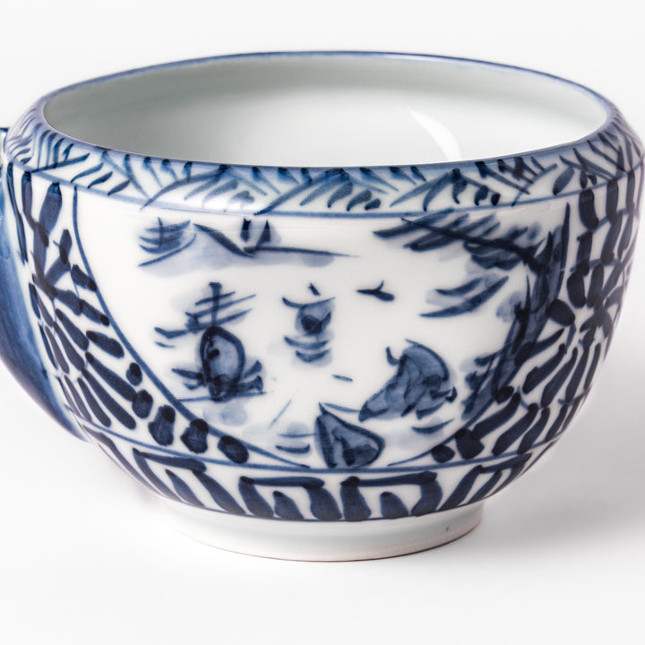 Porcelain sake pourer with spout featuring hand-painted indigo landscape and arabesque patterns in a traditional Japanese style.