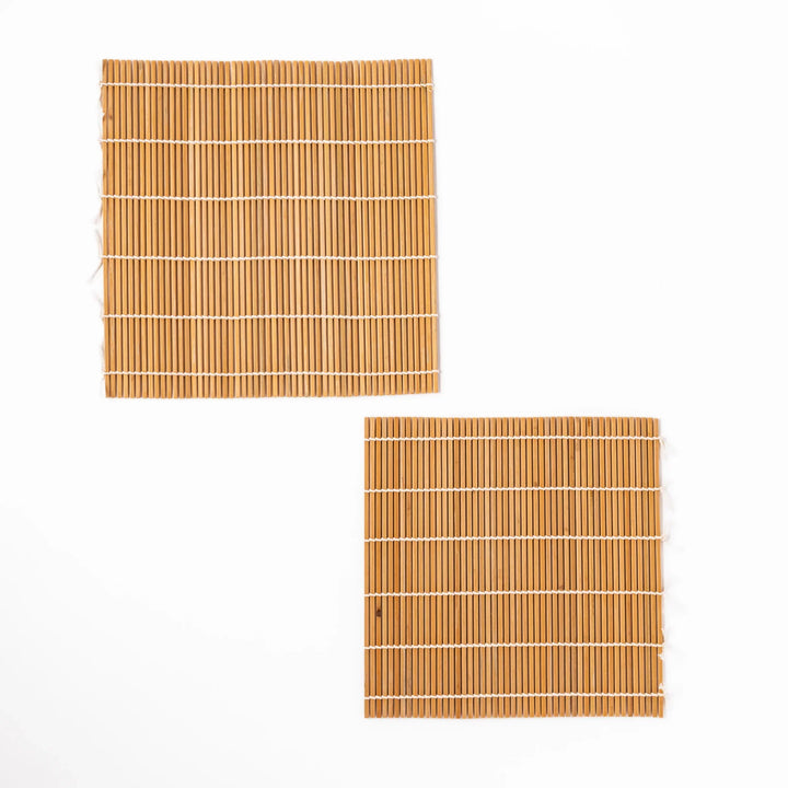 Two bamboo sushi rolling mats with tightly aligned slats and white cotton ties, ideal for crafting precise sushi rolls and enhancing traditional presentation.