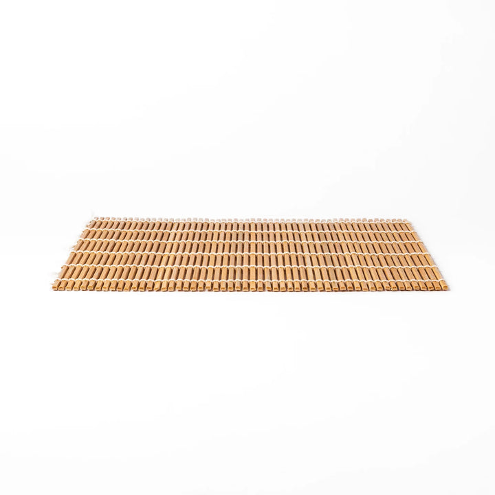 Bamboo sushi rolling mat with smooth, evenly spaced slats and white cotton string, perfect for shaping homemade sushi rolls with traditional style.
