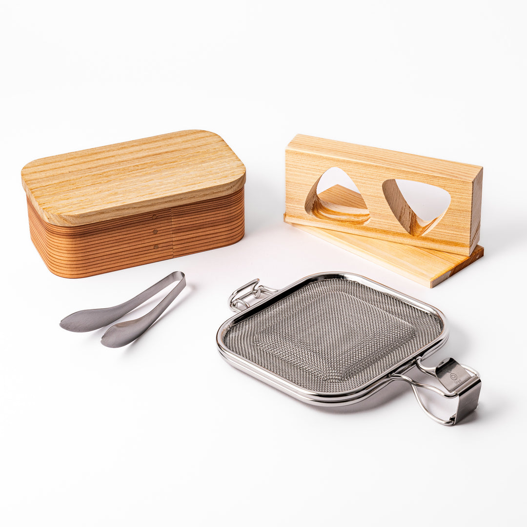 Japanese bento set featuring a wooden lunch box, onigiri mold, stainless steel grilling mesh, and mini tongs, perfect for crafting beautiful homemade lunches with ease.
