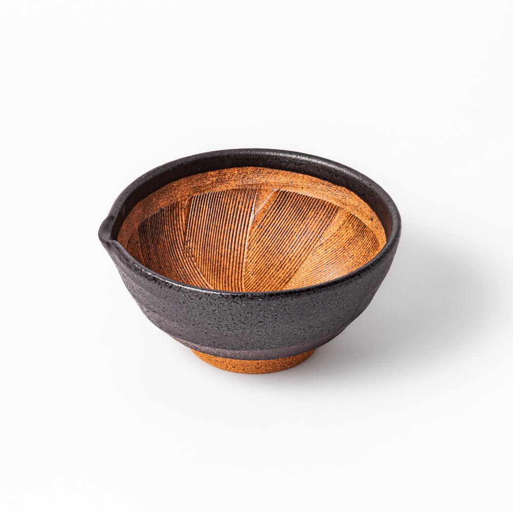 Black ceramic suribachi mortar bowl with rough-textured brown interior grooves and spout, ideal for grinding sesame seeds and other seasonings with precision.