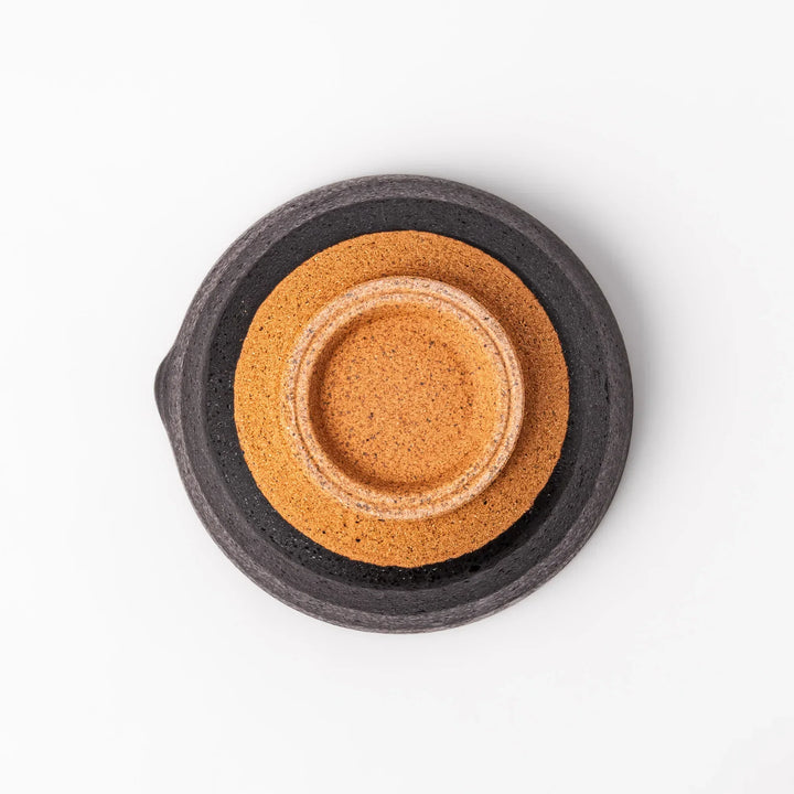 Black ceramic suribachi mortar bowl with rough-textured brown interior grooves and spout, ideal for grinding sesame seeds and other seasonings with precision.