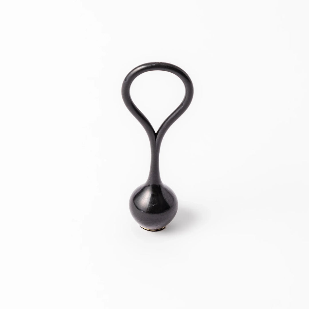 Black meditation bowl striker with looped handle and felt tip for gentle resonant sounds in prayer rituals.