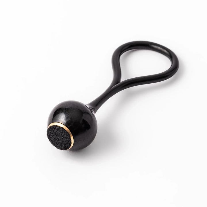 Black meditation bowl striker with looped handle and felt tip for gentle resonant sounds in prayer rituals.