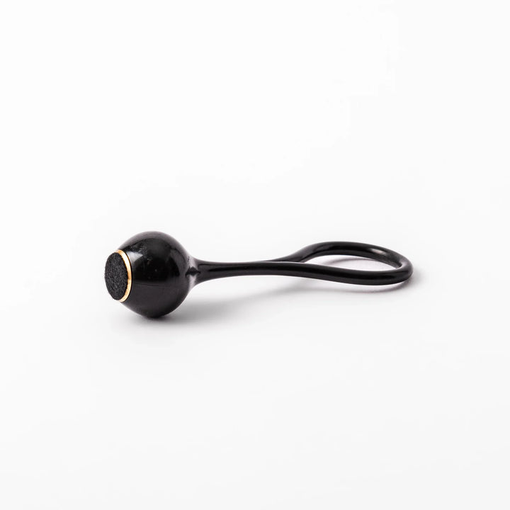 Black meditation bowl striker with looped handle and felt tip for gentle resonant sounds in prayer rituals.