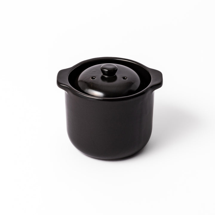 Black ceramic microwave rice cooker with double lid and side handles, designed for convenient cooking and serving at the table.