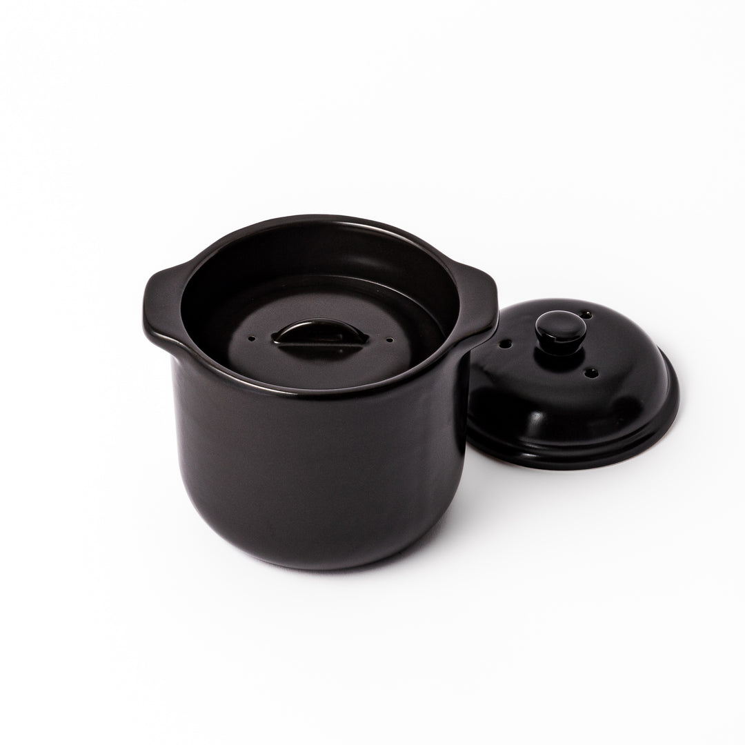 Black ceramic microwave rice cooker with double lid and side handles, designed for convenient cooking and serving at the table.