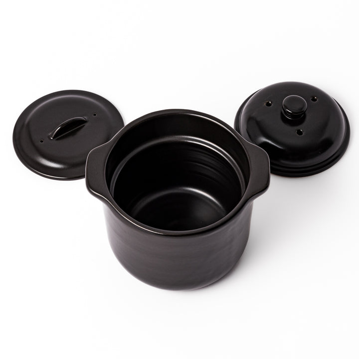 Black ceramic microwave rice cooker with double lid and side handles, designed for convenient cooking and serving at the table.