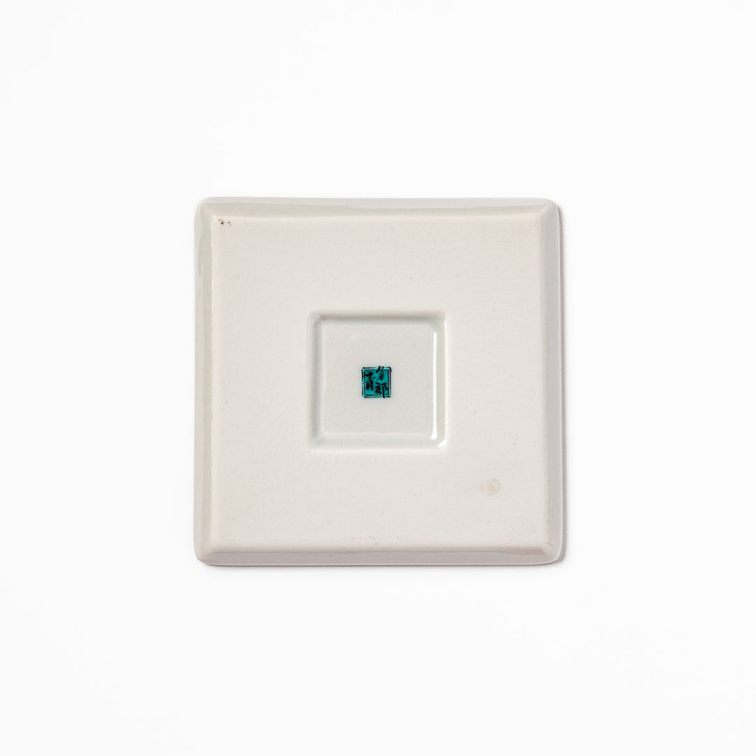 Square Japanese ceramic coaster with vivid red base featuring peony, chrysanthemum, and floral motifs in multicolor design.