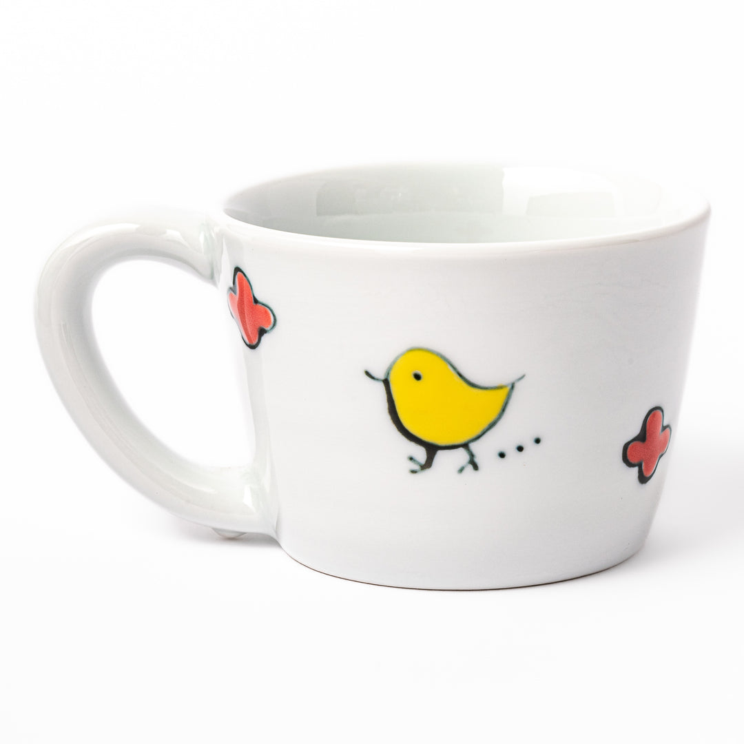 Japanese children’s mug featuring a hand-painted blue bird and musical note design on white porcelain, crafted for little hands to enjoy warm drinks with joy.