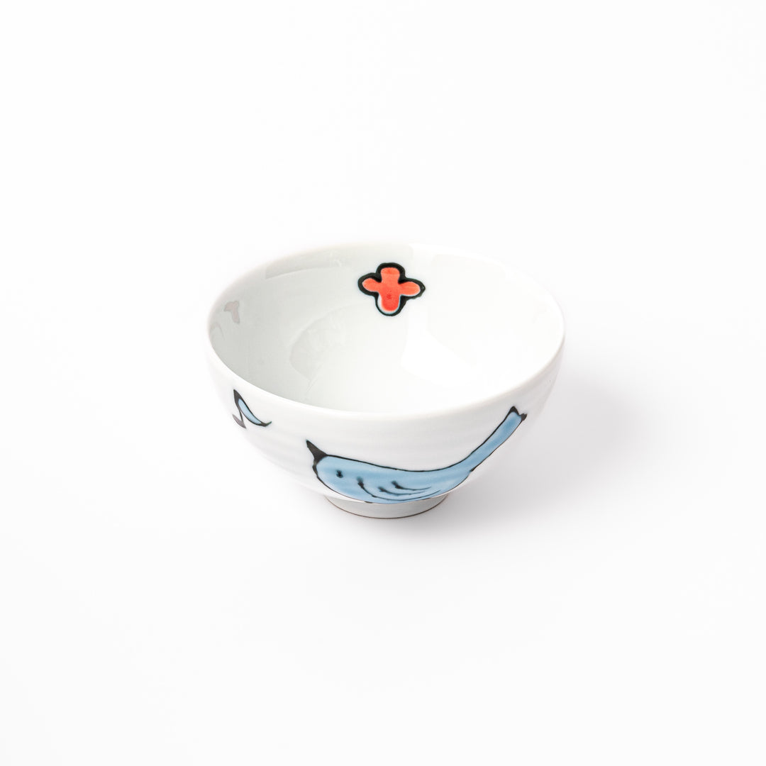 Japanese children’s rice bowl featuring a hand-painted blue bird and musical note motif on white porcelain, designed to bring a cheerful touch to everyday meals.