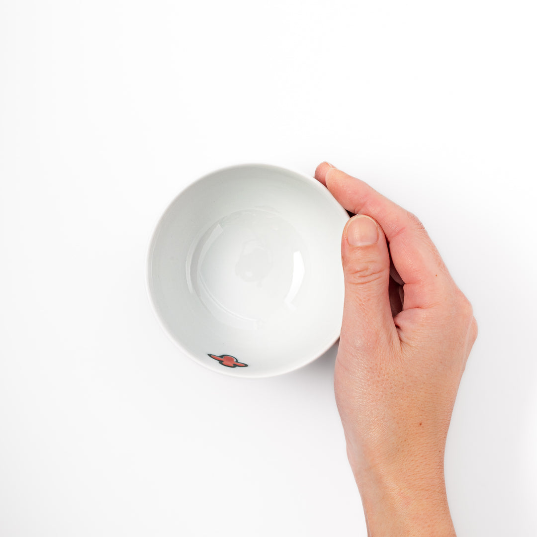 Japanese children’s rice bowl featuring a hand-painted blue bird and musical note motif on white porcelain, designed to bring a cheerful touch to everyday meals.