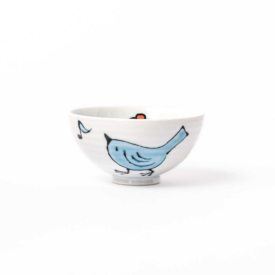 Japanese children’s rice bowl featuring a hand-painted blue bird and musical note motif on white porcelain, designed to bring a cheerful touch to everyday meals.