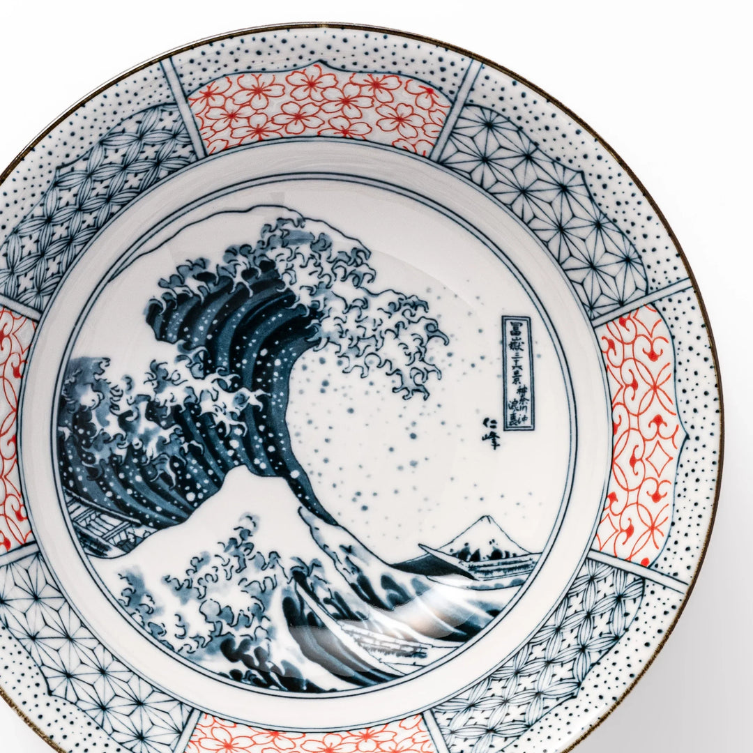 Japanese porcelain ramen bowl featuring Hokusai Great Wave design with red and blue geometric patterns in traditional style.
