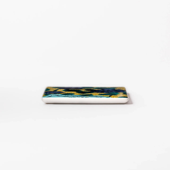 Japanese porcelain coaster with blue peony and green leaf design on yellow background, inspired by traditional Kutani ware.