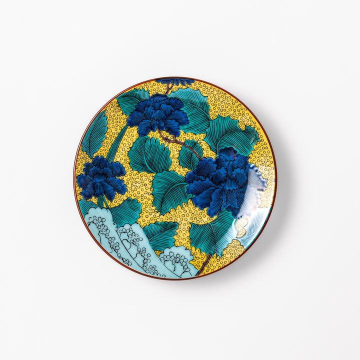 Porcelain dessert plate with bold blue peony flowers, green leaves, and a golden yellow background accented by intricate dot patterns.